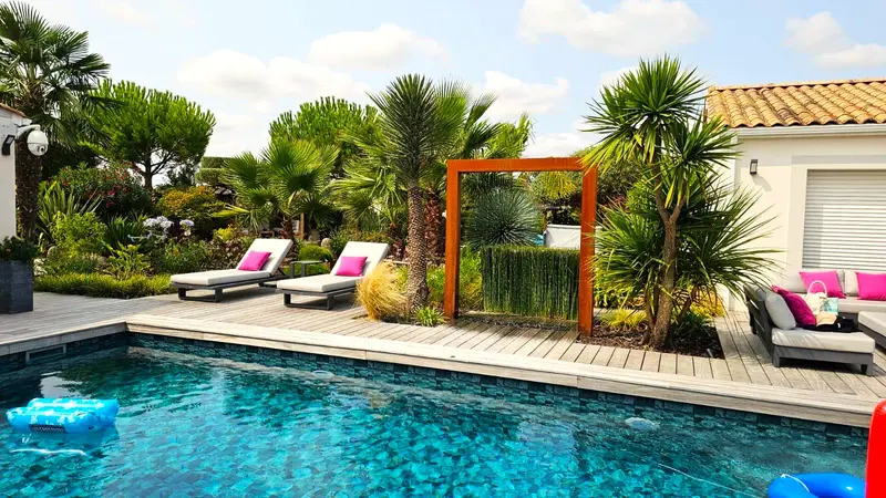 La piscine chauffée de la villa Serenity, ses transats et l’arche corten